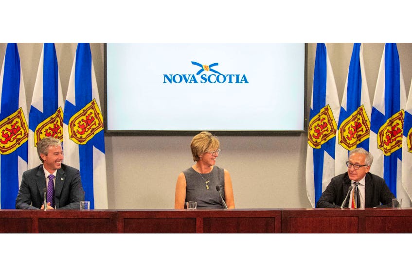 Premier Tim Houston shares a moment during Tuesday's news conference with Karen Oldfield and Dr. Kevin Orrell, members of the Progressive Conservative government's new health-care leadership team.