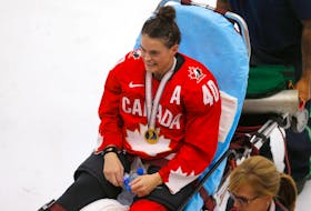 Blayre Turnbull of Stellarton rests on a stretcher with her gold medal following Canada's 3-2 overtime win over the United States in the championship game of the IIHF women's world hockey championship on Tuesday in Calgary. Turnbull suffered a broken fibula in the celebration of the victory. POSTMEDIA