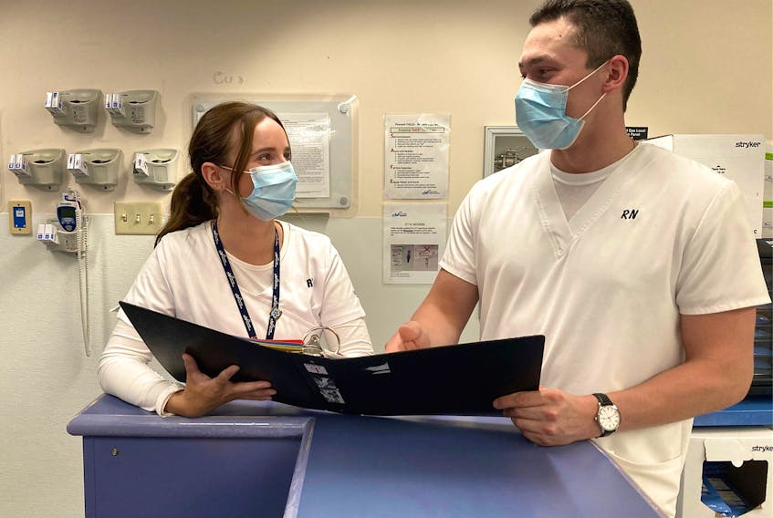 Registered nurses Brittani Andrews, left, and Tyrel Carroll, review a patient chart on Unit 4A, a medical unit at Cape Breton Regional Hospital. There are more than 1,300 nurse vacancies province-wide, including almost 300 in Cape Breton. Lynn Gilbert/Nova Scotia Health