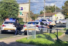 Police with drawn weapons aim at a residence on Campbell Ave. in St. John's Saturday afternoon. — Joe Gibbons/The Telegram