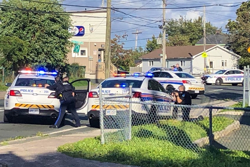 Police with drawn weapons aim at a residence on Campbell Ave. in St. John's Saturday afternoon. — Joe Gibbons/The Telegram