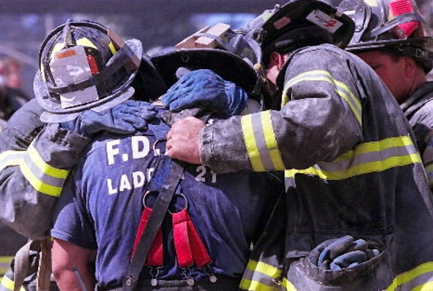  Firefighters grieve for their colleagues following the collapse of the World Trade Center towers, Tuesday.