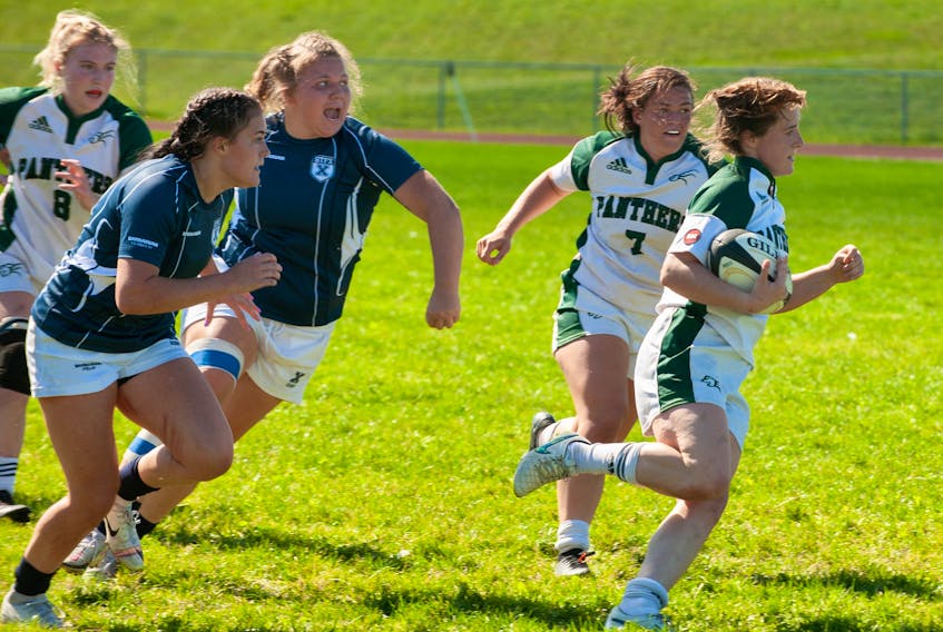 UPEI's Annika Wadlegger (right) breaks free from a pack of St. Francis Xavier tacklers as Panthers teammate Brinten Comeau (7) looks on during the AUS women's rugby season opener Saturday in Charlottetown. Wadlegger and Comeau had second-half tries in UPEI's stunning 38-31 victory over the X-Women. - Janessa Hogan / UPEI ATHLETICS