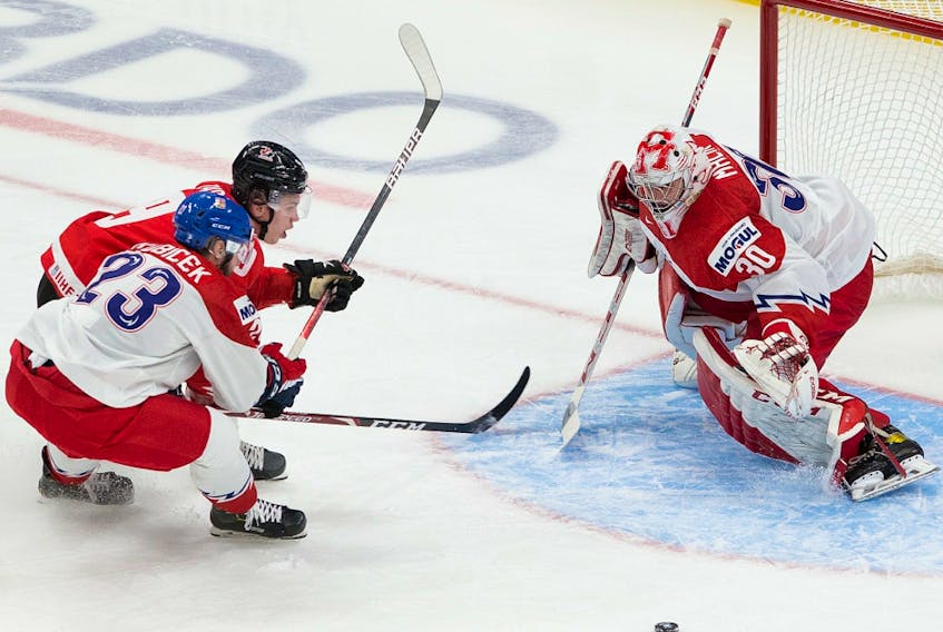 Canada's Connor Zary (9) reaches for the puck against the Czech Republic's Simon Kubicek (23) and goalie Nick Malik (30) in the IIHF world junior championship quarter-final on Jan. 2, 2021 in Edmonton.