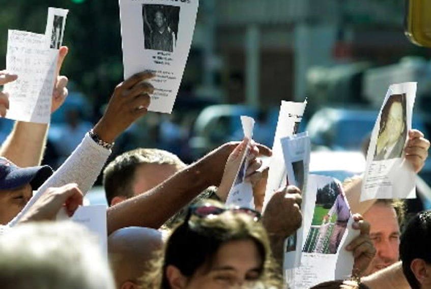  Friends and family hold up pictures of thier loved ones to TV cameras in downtown New York on Thursday, September 13, 2001.