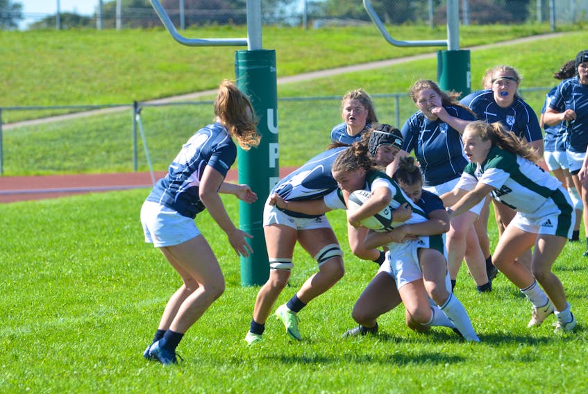 The UPEI Panthers’ Kenzie Hale, holding the ball, attempts to escape the tackle attempts of the St. Francis Xavier X-Women. Maddy Clements, right, of the Panthers, supports Hale. The Panthers’ won the Atlantic University Sport women’s rugby game at UPEI 38-31 on Sept. 11.