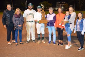 Valerie Grady, fifth from the left, presents the Colin (Coke) Grady Memorial championship trophy to Capital District Islanders co-captain Elijah Hood, fourth left, recently. The Island Junior 22-Under Baseball League (IJBL) named its championship trophy in memory of Grady, a respected player and minor baseball instructor in Summerside. Also taking part in the presentation are, from left, Blair Creelman, vice-president of the IJBL; Darlene Grady, daughter of Coke Grady; Johnny Savidant, co-captain of the Islanders; daughter Shelly Williams; Breanna Sheppard and Beau Palmer, granddaughter and great-grandson, and granddaughter Kayla Grady.