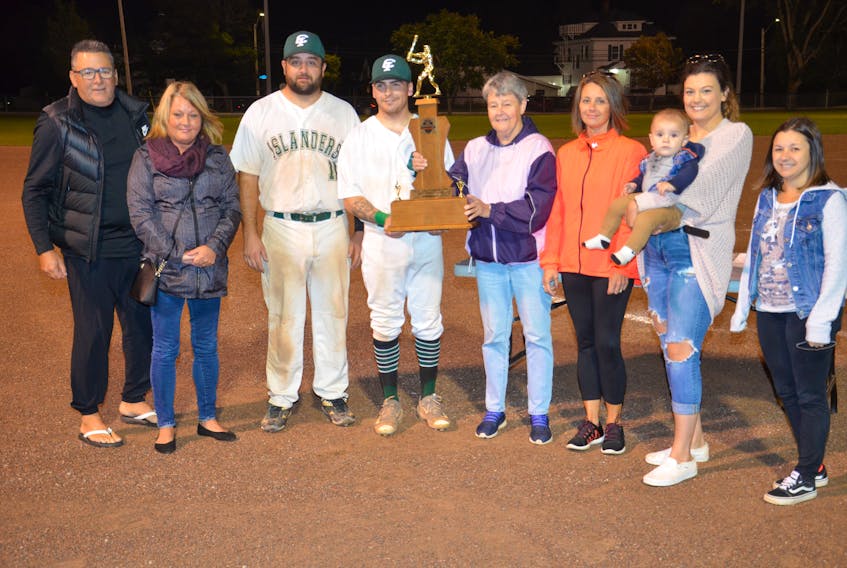 Valerie Grady, fifth from the left, presents the Colin (Coke) Grady Memorial championship trophy to Capital District Islanders co-captain Elijah Hood, fourth left, recently. The Island Junior 22-Under Baseball League (IJBL) named its championship trophy in memory of Grady, a respected player and minor baseball instructor in Summerside. Also taking part in the presentation are, from left, Blair Creelman, vice-president of the IJBL; Darlene Grady, daughter of Coke Grady; Johnny Savidant, co-captain of the Islanders; daughter Shelly Williams; Breanna Sheppard and Beau Palmer, granddaughter and great-grandson, and granddaughter Kayla Grady.