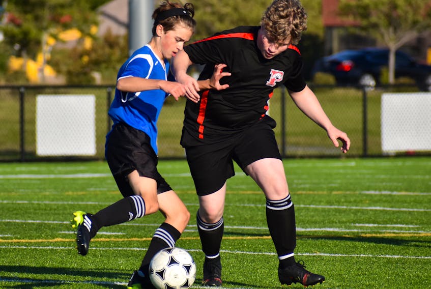 Cole Hutchison-Mills of the Sydney Academy Wildcats, left, works his way around Zack O'Keefe of the Glace Bay Panthers during opening day of the Cape Breton High School Soccer League boys action at Open Hearth Park Turf in Sydney on Monday. Sydney Academy won the game 4-1.  JEREMY FRASER/CAPE BRETON POST.