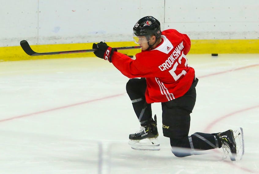Angus Crookshank shoots on Zach Papytsakis of the Ottawa Senators at the Canadian Tire Centre in Ottawa on Monday.