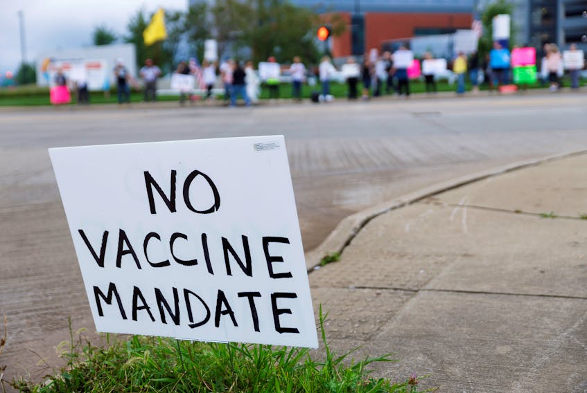 A sign against COVID-19 vaccine mandates is seen in the grass during a protest at Summa Health Hospital in Akron, Ohio. U.S. President Joe Biden recently urged unvaccinated Americans to get jabs and declared ‘vaccine mandates’ that oblige federal employees and companies that employ more than 100 people to do so. REUTERS/Stephen Zenner