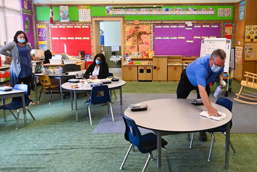  A man sanitizes tabletop surfaces in a Kindergarten classroom at Hunter's Glen Junior Public School in Scarborough on Sept. 14, 2020. 