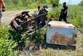 The Cape Breton Environmental Association works with Price is Right Moving and Trucking to remove some heavy items at an illegal dumpsite. Photo by the Cape Breton Environmental Association