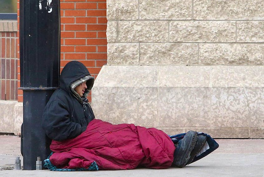  A homeless man tries to stay warm on the corner of 17th Avenue and 7th Street S.W. in downtown Calgary on Jan. 25, 2021.