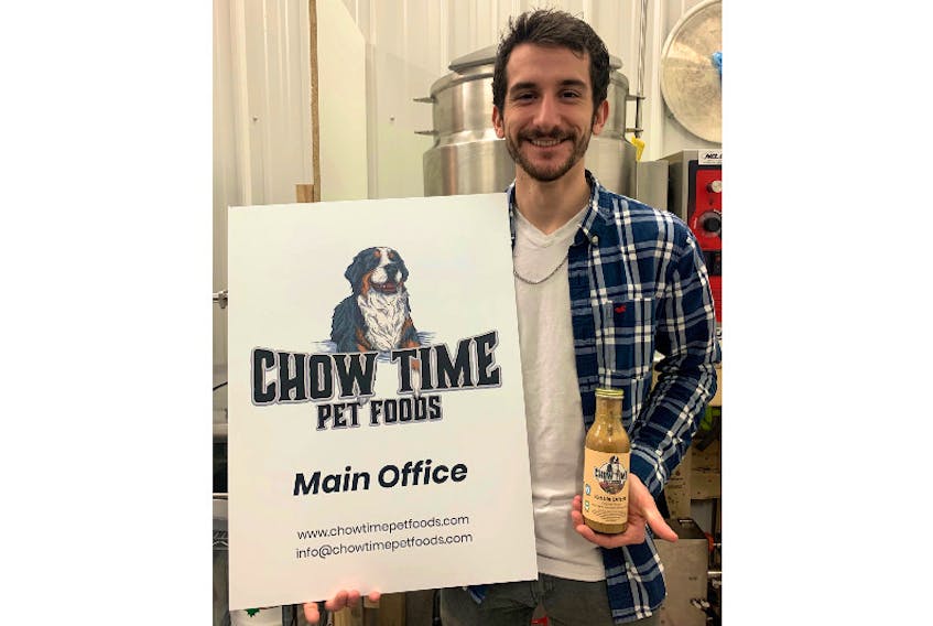 Chow Time Pet Foods CEO Zack Montreuil holds a bottle of his company's pet food sauce Kibble Drizzle. 