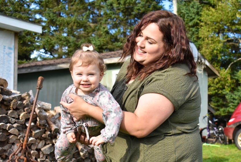 April Bernard swings her 19-month-old daughter, Tinsley, in the front yard of her father's Oyster Bed Bridge home. 