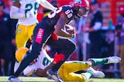 Calgary Stampeders receiver Kamar Jorden runs after a catch against Darius Williams and Brian Walker of the Edmonton Elks at McMahon Stadium in Calgary on Monday, Sept. 6, 2021.