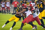  Hamilton Tiger-Cats receiver Papi White is stopped by the Calgary Stampeders’ defence at Tim Hortons Field in Hamilton, Ont. on Friday, Sept. 17, 2021.