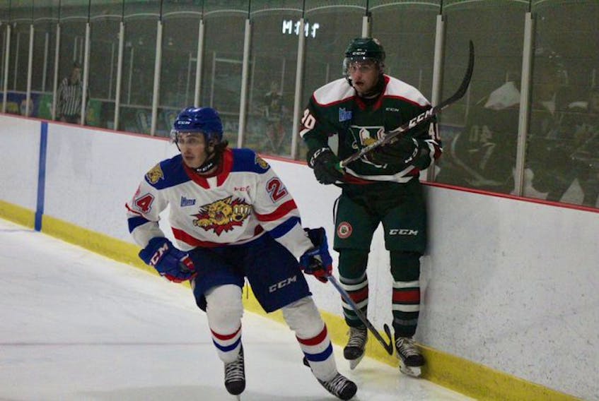 Halifax Mooseheads defenceman David Lafrance and Moncton Wildcats forward Ethan Dollemont track the puck during a QMJHL exhibition game in Moncton on Saturday.