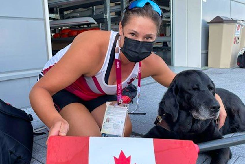 Canadian Paralympian Victoria Nolan with her guide dog, Alan, in front of the rowing course with one of the Canadian team’s oars. Despite laws guaranteeing her and her dog access to shops and services in Canada, she says she is often denied that right.