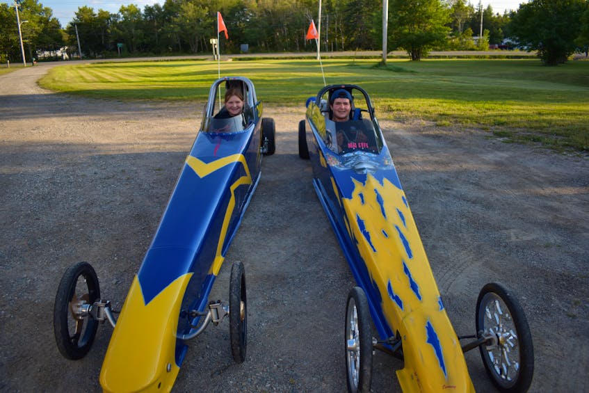 Jacey Pozzebon, left, and her brother Gavin Pozzebon sit in the driver's seats of their respective dragsters at the family’s home in Gardiner Mines on Wednesday. The two will be competing at Cape Breton Dragway in Sydney this weekend. JEREMY FRASER • CAPE BRETON POST