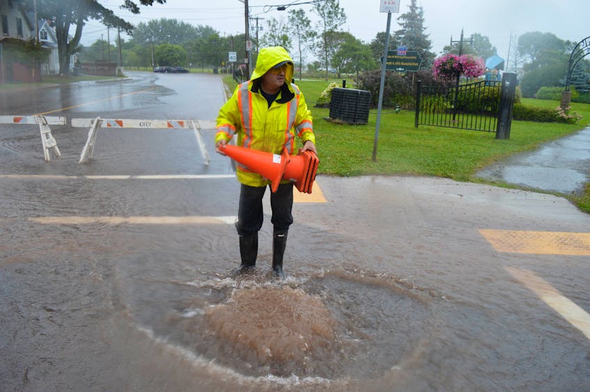 Brent MacRae, chief of the catch basin crew with the City of Charlottetown, surveys the scene as water gushes out of a catch basin at the corner of Kent and Edward streets on Sept. 2. - Dave Stewart • The Guardian