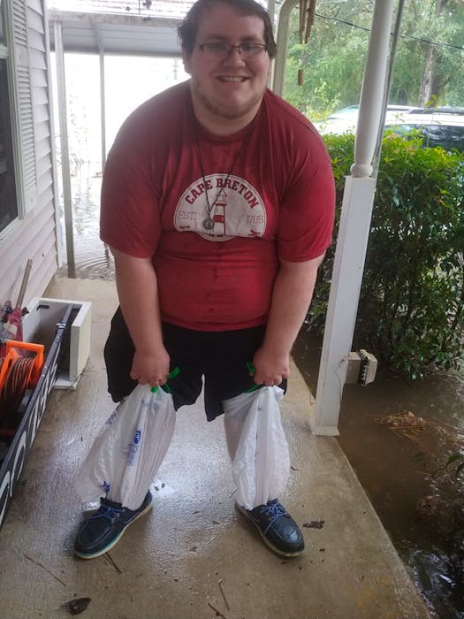 A.J. Albert gets ready to leave his home in Slidell, La., by placing garbage bags over his legs to keep them dry and to avoid insect and snake bites. CONTRIBUTED/CARMEL ALBERT