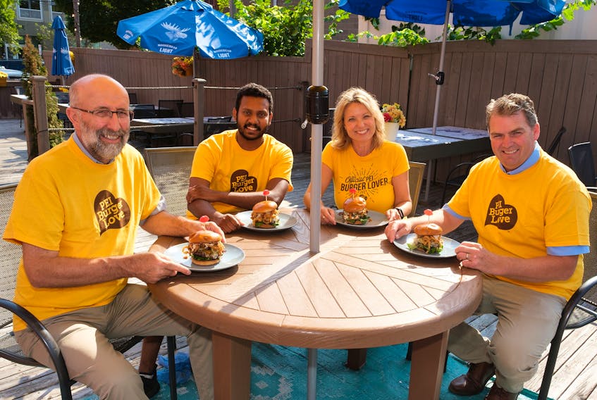Ron Maynard, president P.E.I. Federation of Agriculture (far left) enjoys a burger with The Old Triangle chef George Joseph (second from left), president and creative director of Fresh Media Melody Dover and Agriculture and Land Minister Bloyce Thompson.