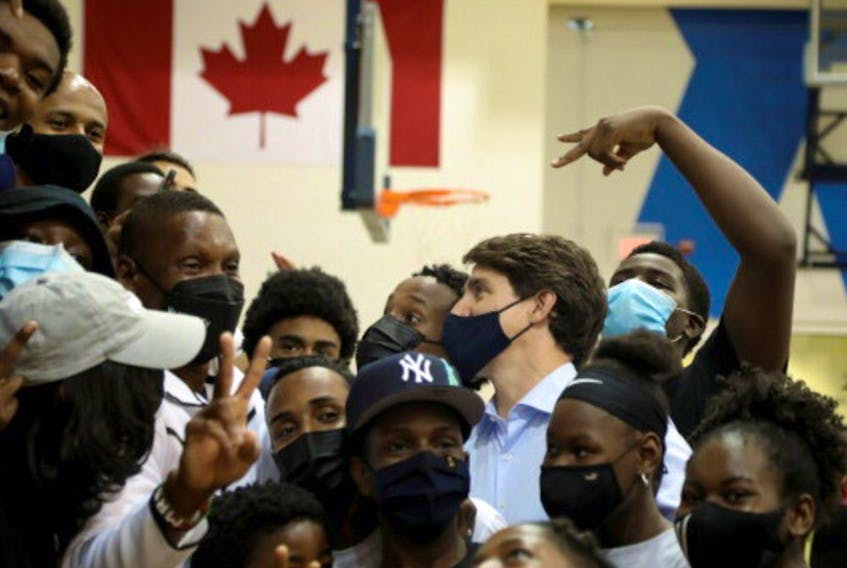 Canada's Liberal Prime Minister Justin Trudeau talks to members of the Toronto Raptors youth programs, alongside Masai Ujiri, the President of the team, at the Mattamy Athletic Centre during Trudeau's election campaign tour in Toronto, Ontario, Canada September 1, 2021.