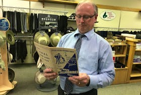 Scott MacVicar, fourth generation owner of Spinner’s Men’s Wear in downtown Sydney, looks over the Sydney Millionaires program in his downtown store. Contributed • Paul MacDougall