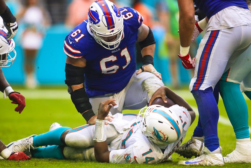  Buffalo Bills defensive tackle Justin Zimmer (61) glares down at Dolphins quarterback Jacoby Brissett after sacking him during the fourth quarter of the game at Hard Rock Stadium in Miami. (Sam Navarro, USA Today Sports)