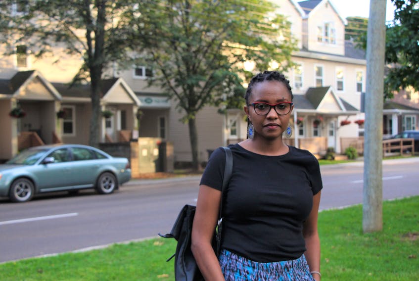 Flossie Mbiriri stands around the corner from the apartment building where she paid $100 to stay one night. 