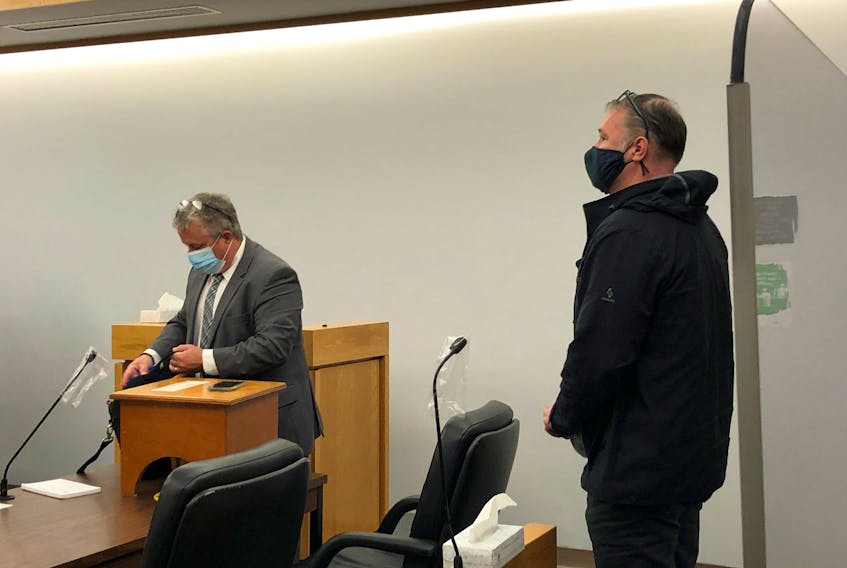 Todd Gillingham (right) waits for his lawyer, Jason Edwards, before leaving a St. John's courtroom Monday morning. Gillingham pleaded guilty to a number of charges and will be back in court in March for sentencing.