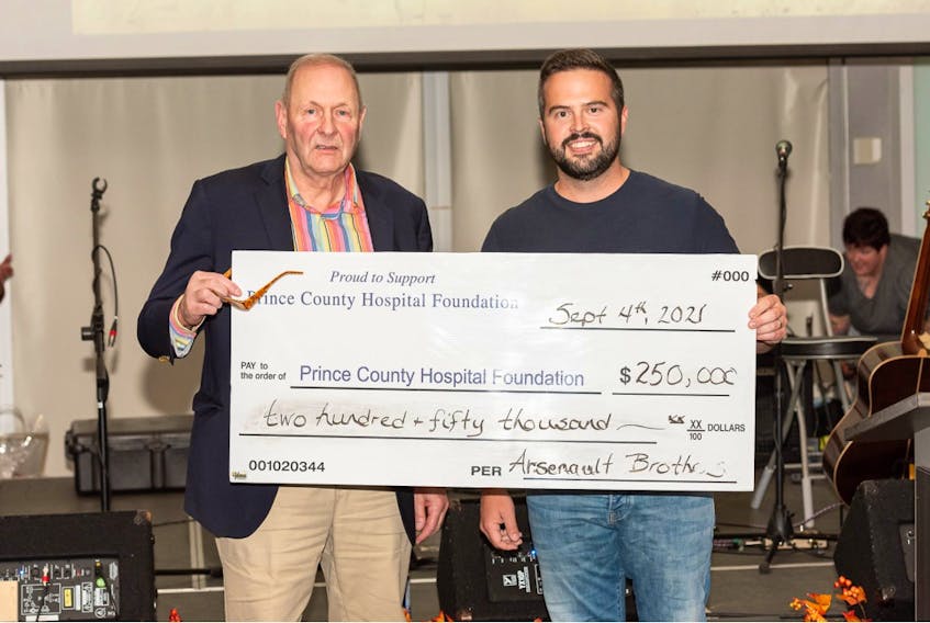Lucas Arsenault, right, president of Arsenault Bros., presents event organizer Warren Ellis with a 10-year, $250,000 commitment to the Prince County Hospital Foundation at the Sept. 4 Grass Roots and Cowboy Boots auction.