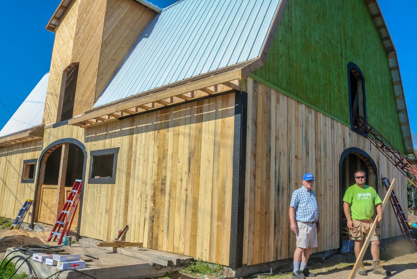 Chris Gorey, left, and Ryan Costelo, right, stand in front of the partially rebuilt Groovy Goat Farm & Soap Company's barn, in Ingonish on Wednesday. The Groovy Goat has been rebuilding its barn following the loss of the original, which housed goats, horses and chickens, to a massive fire in late February 2021. The company, owned by Ryan and Shannon Costelo, began a community-driven rebuild in late July and have been working on it ever since. JESSICA SMITH/CAPE BRETON POST