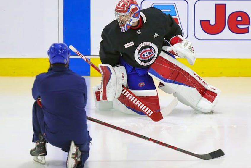 Montreal Canadiens goalie Carey Price does some exercises on the ice under the supervision of a member of the team's training staff at the Bell Sports Complex in Brossard on Sept. 16, 2021.