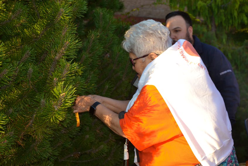 Katie McEwan, an elder and residential school survivor from Membertou, ties the first orange ribbon to the Tree of Rememberance outside the Port Hawkesbury Civic Centre as Coun. Steven Googoo from We'koqma'q looks on. ARDELLE REYNOLDS/CAPE BRETON POST