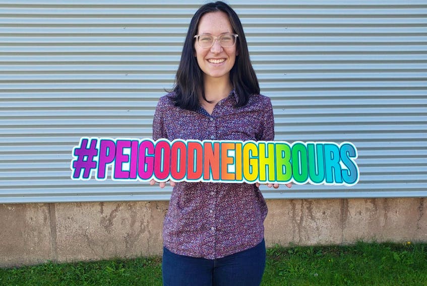 Lindee Gallant holds up a sign with hashtag #PEIGoodNeighbours. She encourages people across the Island to share stories of neighbours' good deeds using this hashtag. 