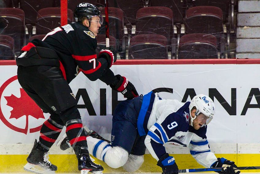  Senators left-winger Brady Tkachuk (7) checks Jets centre Andrew Copp in a game in Ottawa on Jan. 19.