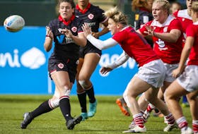 anada's Alysha Corrigan, front left, passes the ball as Britain's Megan Jones grabs her during a women's HSBC Canada Sevens rugby match in Edmonton on Sept. 25, 2021. 