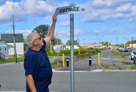 Coal Town Trail Society member Allister MacLean checks out the damage to a recently-erected street sign in the downtown Glace Bay section of the 15-km trail that connects Gardiner Mines with Tower Road. MacLean said a stop sign affixed to the pole was ripped off and has not been recovered. DAVID JALA/CAPE BRETON POST