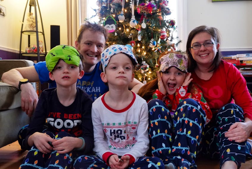 Alex and Jenna Morton, with their sons Alasdair and Rory and daughter Clara, wear homemade eye masks on Christmas morning. The family has a tradition of exchanging handmade items each Christmas.