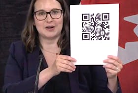 Digital Government Minister Sarah Stoodley shows what a QR code looks like during a news briefing in St. John's Tuesday.