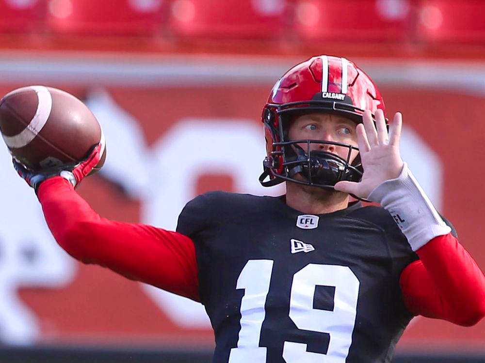 Calgary Stampeders coach Dave Dickenson speaks with quarterback Bo