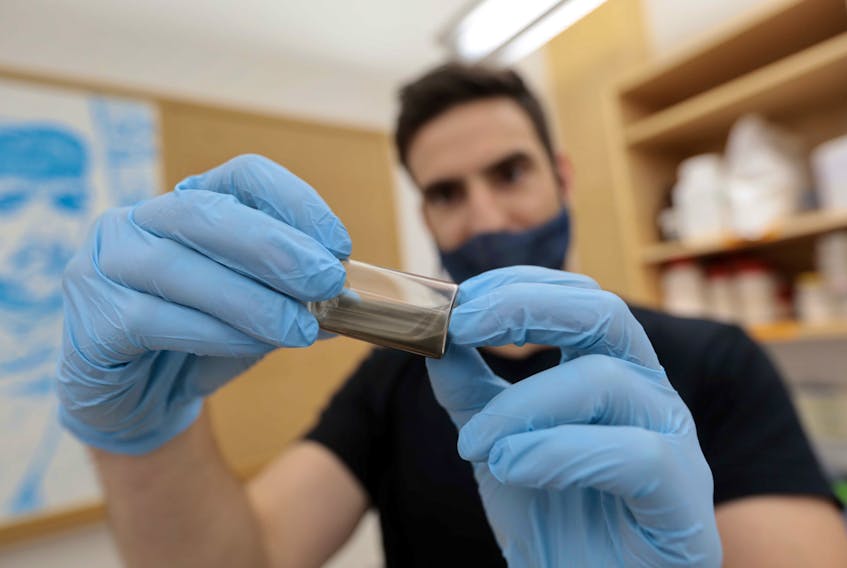 John Frampton, an associate professor at Dalhousie's School of Biomedical Engineering, holds a vial of polymer paste at his lab in Halifax. - Eric Wynne
