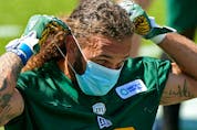  Defensive halfback Aaron Grymes puts on a face mask during Edmonton Elks training camp at Commonwealth Stadium on July 12, 2021. The team resumed full practices Thursday after serving a 10-day quarantine where 13 players tested positive for COVID-19.
