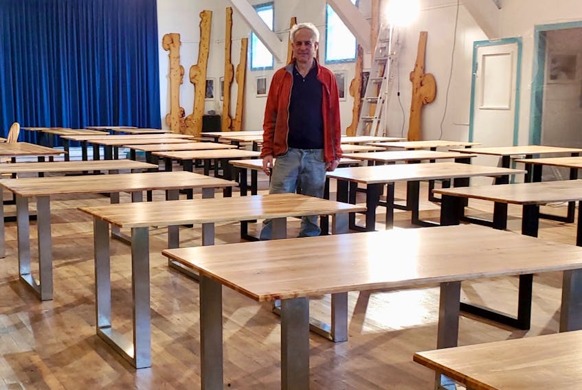 Neal Livingston stands in the midst of his collection of recently created dining room tables at his storage facility in western Cape Breton. The Inverness County woodlot owner, filmmaker, renewable-energy advocate, artist and environmentalist began making artistic dining room and coffee tables from lumber harvested on his small woodlot. CONTRIBUTED