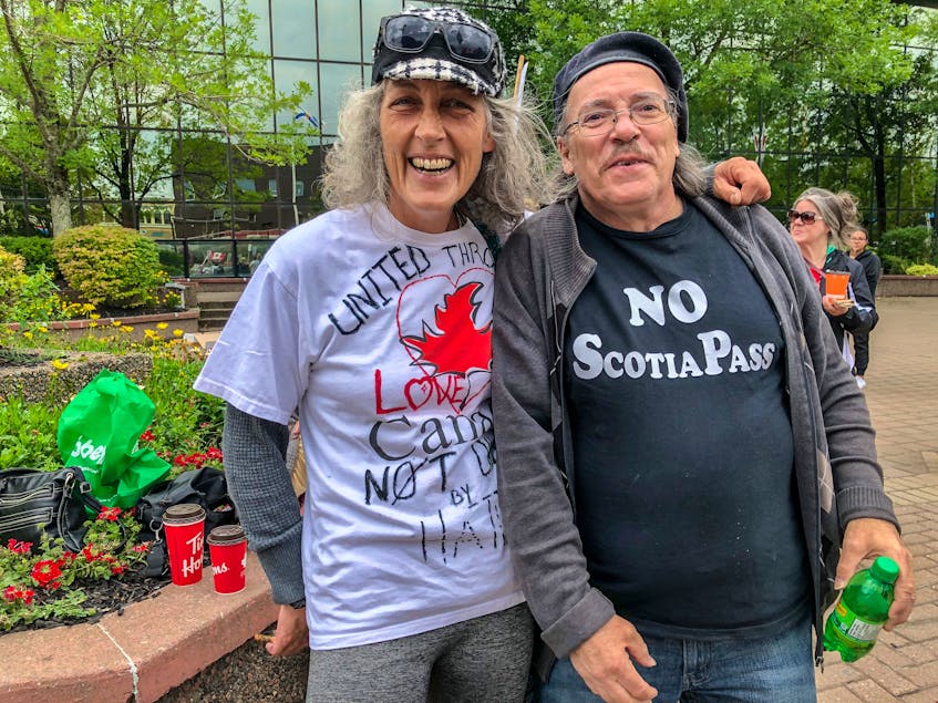 A protester who gave her name as Shara McPuffin, left, with David Martin, right, at the rally in front of City Hall in Sydney. CAPE BRETON POST