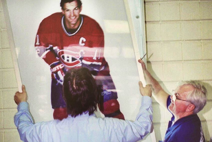  Workers at the Forum take down poster of captain Kirk Muller after he was traded to the New York Islanders on April 5, 1995.