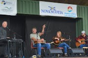 John Curtis Sampson, second from left, prompts the crowd to sing along with Kim Dunn, left, as Norma MacDonald and Jason MacDonald look on during a songwriters circle segments of the Acoustic Roots Festival on Sunday afternoon at Two Rivers Wildlife Park. — IAN NATHANSON/CAPE BRETON POST 